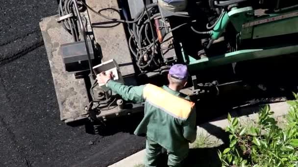 Speciale apparatuur straatstenen en werknemers leggen nieuwe asfalt mix op de weg. Wegenreparatiesector — Stockvideo