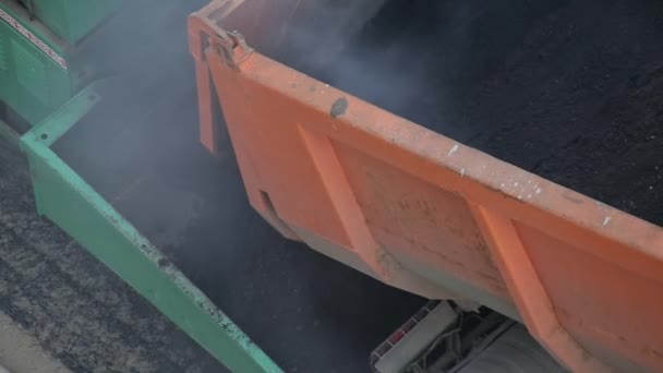 Il camion discarica versa asfalto caldo nel paver, lavori stradali, industria . — Video Stock