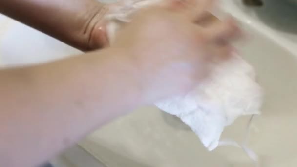 Девушки руки мыть многоразовые защитные медицинские маски для лица во время пандемии. Концепция повторного использования защитных масок во время коронавируса — стоковое видео