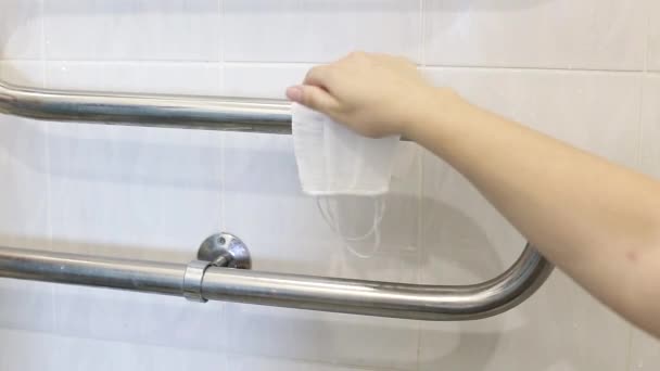 Meisje hangt herbruikbare beschermende maskers op een handdoek te drogen na het wassen in de badkamer. Het concept van hergebruik van medische maskers tijdens het coronavirus — Stockvideo