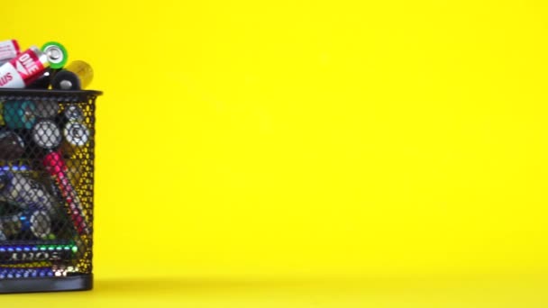 BOBRUISK, BELARUS 10.08.2020: Koš s odpadními bateriemi na žlutém pozadí. Koncept recyklace baterií, obchod, kopírovací prostor pro text — Stock video
