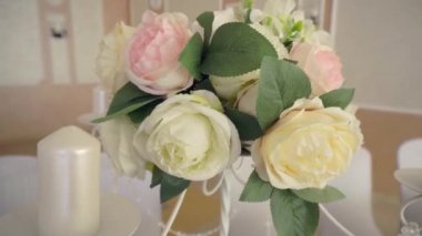 Masanın üzerinde duran güllerden oluşan bir buket tatili ve mülkü, arka planı, dekorasyonu süslemek için duruyor.