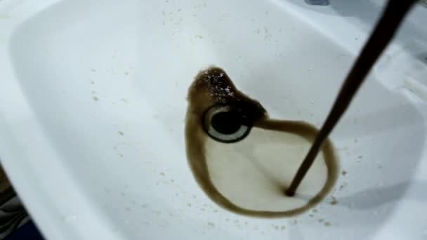 Rostiga och smutsiga vatten rinner från kranen in i diskhon. Renande av kranvatten, reparation av vattenledningar, industri — Stockvideo