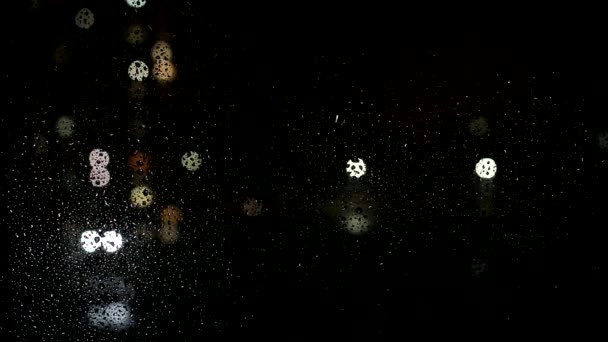 Regendruppels op het glas van het raam, buiten het raam de straat auto 's besturen, slecht weer. Achtergrond, kopieer ruimte voor tekst, nacht — Stockvideo