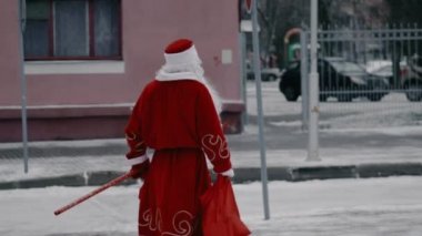 Rus Ded Moroz, Noel Baba gibi kış şehrinde hediyeler vermek için yürüyor. Noel ve Yeni Yıl konsepti. Dalları olan zayıf bir adam.