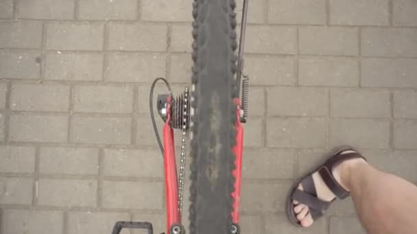 En man rullar en cykel med punkterat däck på hjulet, punkterat däck — Stockvideo