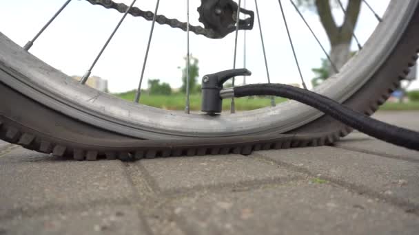 Muž nafoukne kolo na kole čerpadlem, zblízka, transportem — Stock video