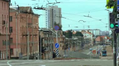 Minsk şehrinde eski mimari, şehir trafiği ve tramvaylarla dolu bir sokak.