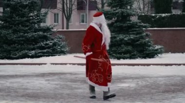 Rus Ded Moroz, Central City meydanında yürüyen Noel Baba gibi. Noel ve Yeni Yıl konsepti. Dalları olan zayıf bir adam.