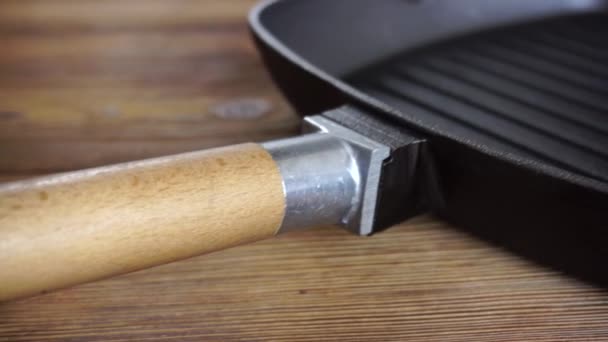 Padella griglia in ghisa con manico in legno removibile su fondo in legno. Delizioso e sano concetto di cucina, utensili da cucina, spazio copia per il testo — Video Stock