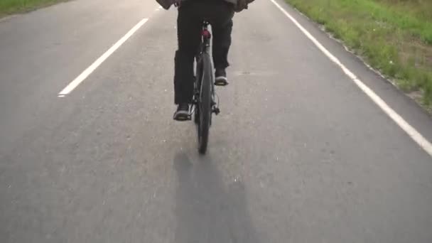 Человек в спортивном костюме ездит на велосипеде, колесо велосипеда едет по асфальту, крупным планом, спортивным — стоковое видео