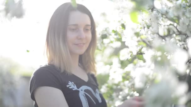 Дівчина в квітучому саду — стокове відео