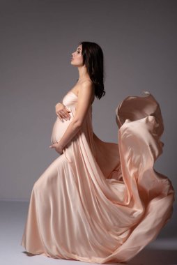 Dokuların içinde hamile bir kız. Moda Hamileliği