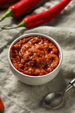 Bir kase sıcak kırmızı Calabrian biber sosu yaymak