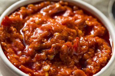 Bir kase sıcak kırmızı Calabrian biber sosu yaymak