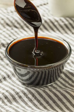 Bir kase içinde organik siyah şeker kamışı pekmezi