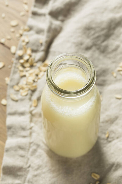 Органическое белое овсяное молоко в стакане
