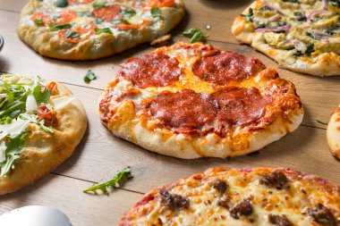 Gurme ev yapımı çeşitli ahşap pizza Pepperoni fesleğen ve peynir ile ateş