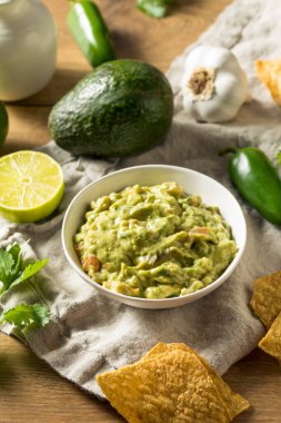 Homemade Organic Guacamole and Chips with Lime clipart