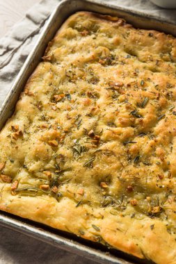 Ev yapımı sarımsak ve zeytinyağlı biberiye Focaccia ekmeği.