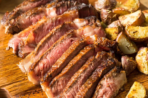 草Fed Ribeyeステーキとジャガイモを食べる準備ができて — ストック写真