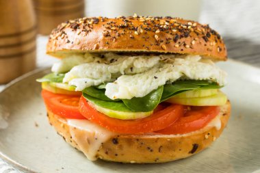 Domates ve salatalıklı ev yapımı sağlıklı yumurtalı bagel sandviçi.