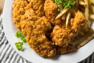 Kızarmış tavuk ve soslu patates kızartması.