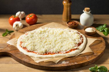 Ev yapımı pişmemiş peynirli PIzza sosu ve hamur ile hazırlanıyor.