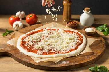 Ev yapımı pişmemiş peynirli PIzza sosu ve hamur ile hazırlanıyor.