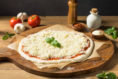 Ev yapımı pişmemiş peynirli PIzza sosu ve hamur ile hazırlanıyor.