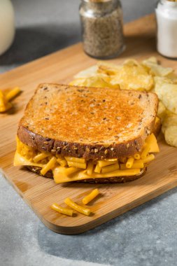 Ev yapımı ızgara makarna ve Cheddar ve Chips 'li peynirli sandviç.