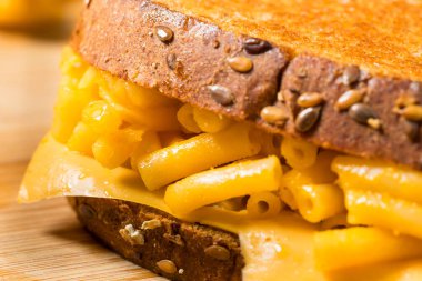 Ev yapımı ızgara makarna ve Cheddar ve Chips 'li peynirli sandviç.