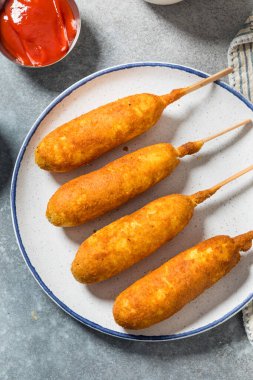 Hardallı ve ketçaplı ev yapımı kızarmış sosisli sandviç.