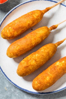 Hardallı ve ketçaplı ev yapımı kızarmış sosisli sandviç.