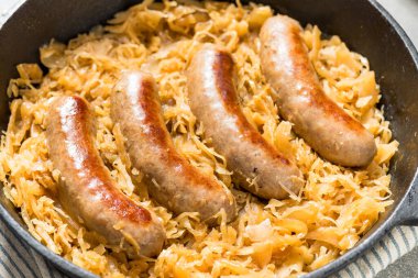 Homemade Savory Bratwurst and Sauerkraut in a Cast Iron Pan