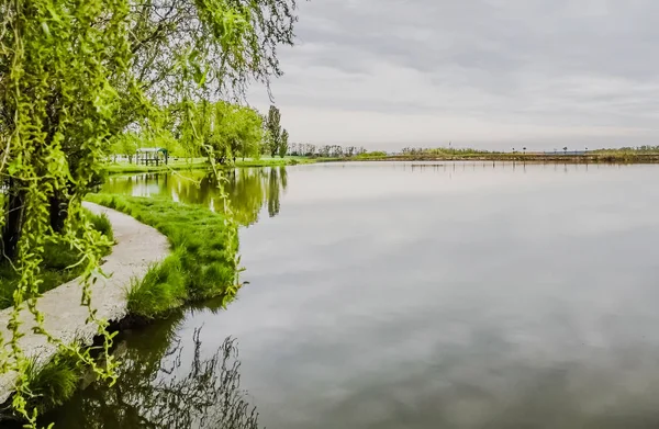 Nature with a lake. Spring time place for relax. Rustic summer landscape. Lake, gazebo, forest.