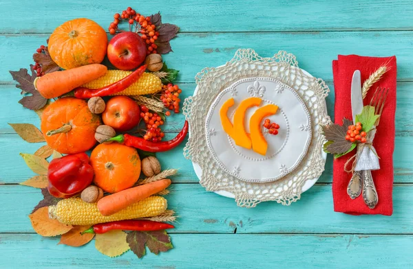 Autumn table setting, menu composition, vintage cutlery, sliced pumpkin. Thanksgiving food, healthy and fresh, top view, flat lay, copy space. Fallen leaves, fruits, vegetables, wooden table.