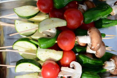 Kadın aşçı et ve diğer sebzeleri ızgarada pişiriyor.