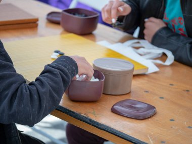 Bir açık masada Çince Go oyunu oynayan insanlar
