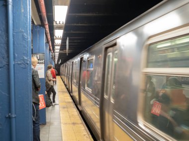 New York, Ny 18 Mayıs 2018-Büyükşehir ulaşım Otoritesi (Mta) metro treninin 81 street istasyonu platformu üzerinde bekleyen yolcular tarafından cilalama