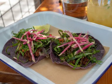 Tropikal bir ortamda Restoran masada oturan iki carne asada tacos