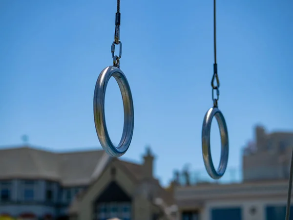 Anillos gimnásticos de acero colgados en un gimnasio al aire libre en un residencial — Foto de Stock