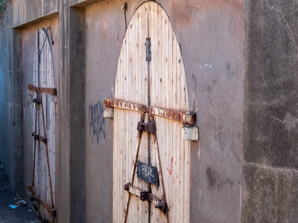 Wooden, graffiti covered door locked in a back alleyway