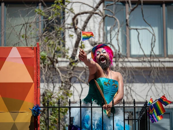 Bärtige Frau steht auf Festwagen und schwenkt bei Pride Parade eine lgbt-Flagge — Stockfoto