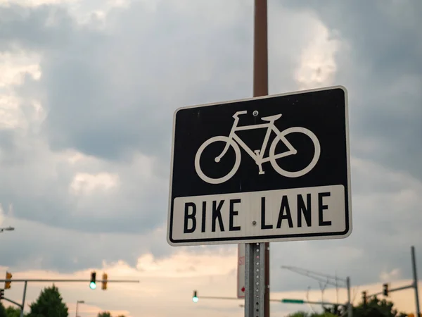 Símbolo de carril bici y signo en el borde de la carretera delante de un cielo nocturno — Foto de Stock