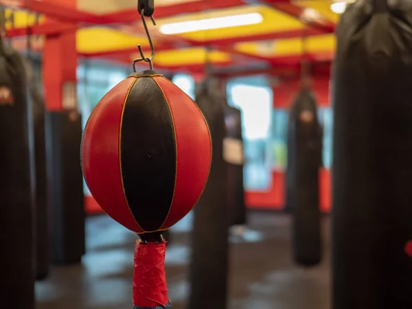 Bolso negro y rojo de doble extremo colgado en un gimnasio deportivo de combate vacío — Foto de Stock