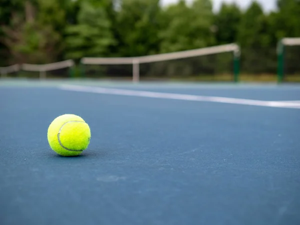 Pelota de tenis verde sentada en la cancha con espacio de copia a la derecha — Foto de Stock