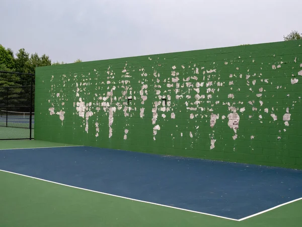 Tenis, lacrosse, pared de práctica de deportes de pelota en una cancha local con pelado de pintura verde — Foto de Stock