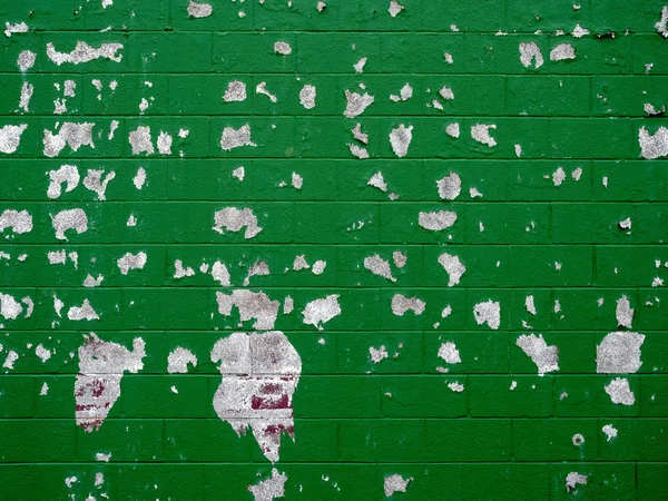 Pintura antigua que se desprende de la pared de ladrillo verde en un entorno al aire libre — Foto de Stock