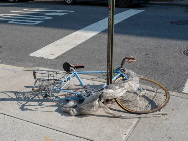 Bicicleta basura envuelta en basura rota en la esquina de la calle — Foto de Stock